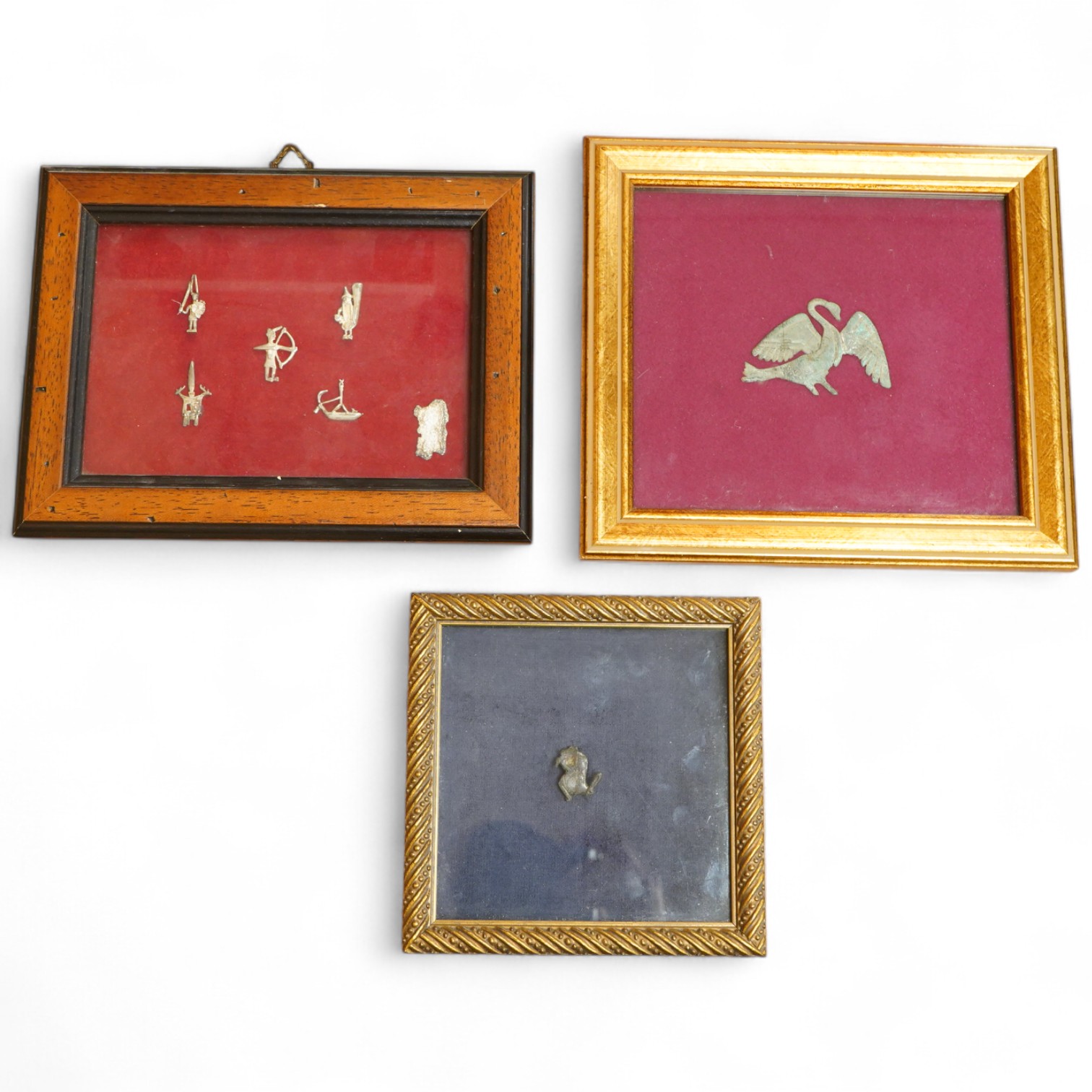 A Roman bronze badge, a medieval pewter badge and silver badges in the form of Sardinia emblems all framed., Swan badge 6cm wide, not including mount or frame. (Requires provenance)